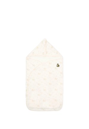 Couverture douce pour bébé en tissu crème avec un motif floral subtil, haut à capuche, et une petite broderie de tigre sur le côté supérieur droit.