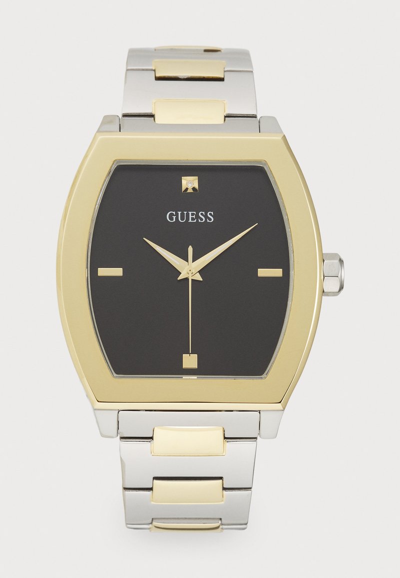 Montre analogique noire avec un cadran carré, une bezel dorée et un bracelet argenté avec des accents dorés. Présente des index d'heure minimalistes et un cristal.