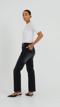 Čierne džínsy s rovným strihom, skombinované s priliehavým bielym tričkom s krátkym rukávom a čiernymi lodičkami s špicatou špičkou.