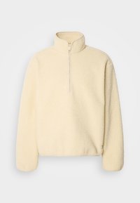 Pullover in pile color crema, con colletto alto e mezza zip, dalla superficie morbida e testurizzata e maniche lunghe.