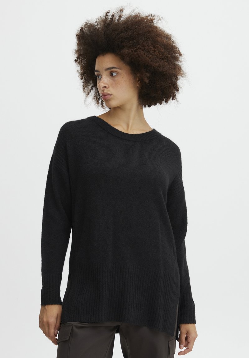 Schwarzer Pullover mit geripptem Saum und Bündchen, langen Ärmeln und entspannter Passform. Die Textur wirkt weich und gestrickt.