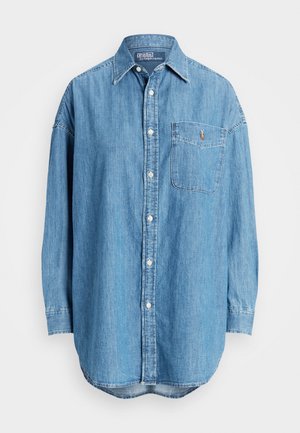Chemise en denim bleu clair à manches longues, avec boutons sur le devant et une poche poitrine ornée d'un petit logo brodé. Col classique.