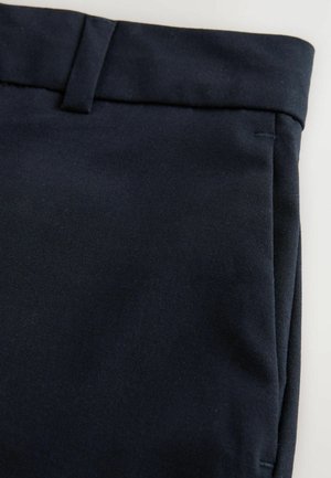 Pantalones de tela azul oscuro con una textura suave, que presentan una cinturilla plana, bolsillos laterales y un detalle de costura limpia.