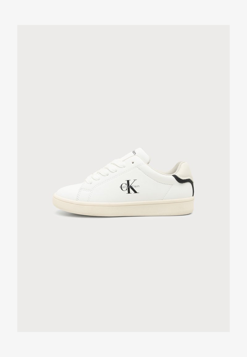 Λευκό Calvin Klein sneaker χαμηλού προφίλ με μαύρο λογότυπο στο πλάι και μαύρη λεπτομέρεια στη φτέρνα, μπεζ σόλα και λευκά κορδόνια σε μονόχρωμο φόντο.