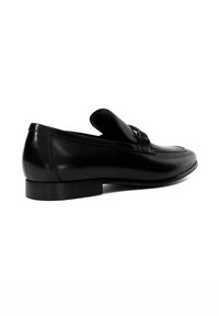 Black leather loafers feature a smooth finish, rounded toe, and a low heel, with a decorative strap across the upper for added detail.