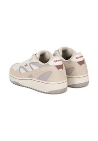 Béžové a šedé tenisky Reebok z kože, zamšenej a sieťovinovej látky. Obsahujú jemné perforácie a červené akcenty loga. Hrubá biela podrážka.