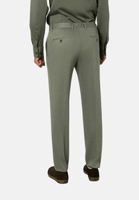 Groene broek met een gestructureerde stof, recht gesneden ontwerp, twee achterzakken en een knoopaccent. Gestyled met een bijpassend overhemd met lange mouwen.