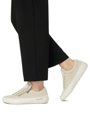 Baskets beige clair en suède texturé et accents en cuir, avec une fermeture éclair sur le côté et une semelle plate en caoutchouc blanc. Design décontracté à lacets.