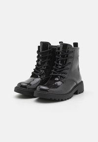 Bottes noires à la cheville avec une finition brillante et scintillante, dotées d'un laçage, d'un bout rond et d'une semelle robuste pour une bonne adhérence.