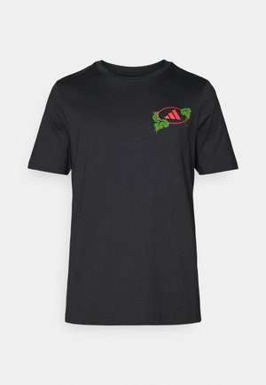 Schwarzes Baumwoll-T-Shirt mit Rundhalsausschnitt. Mit einem lebhaften grünen und roten Grafikdesign auf der linken Brust, das Palmblätter und ein Logo integriert.