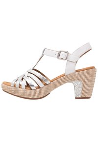 Białe sandały na paskach z srebrnymi akcentami, podwyższoną platformą i teksturowanym, plecionym obcasem. Regulowany pasek na kostkę z detalem w postaci srebrnej klamry.