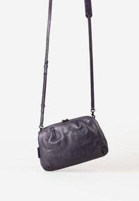 Lila Leder-Crossbody-Tasche mit einem gerüschten Design, verfügt über einen sicheren Klappverschluss und einen verstellbaren Tragegurt für Vielseitigkeit.