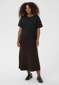Black short-sleeved sweater paired with a brown ankle-length skirt, both made from soft fabric. Black loafers complete the outfit.