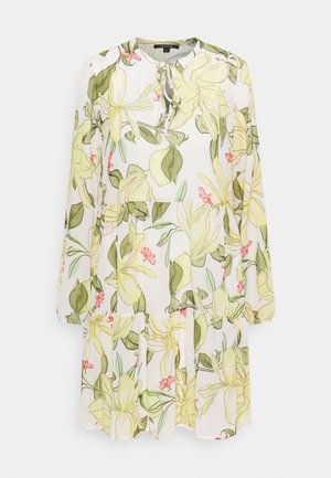 Robe blanche à manches longues avec imprimé floral jaune et vert, col rond, détail noué et jupe à volants.