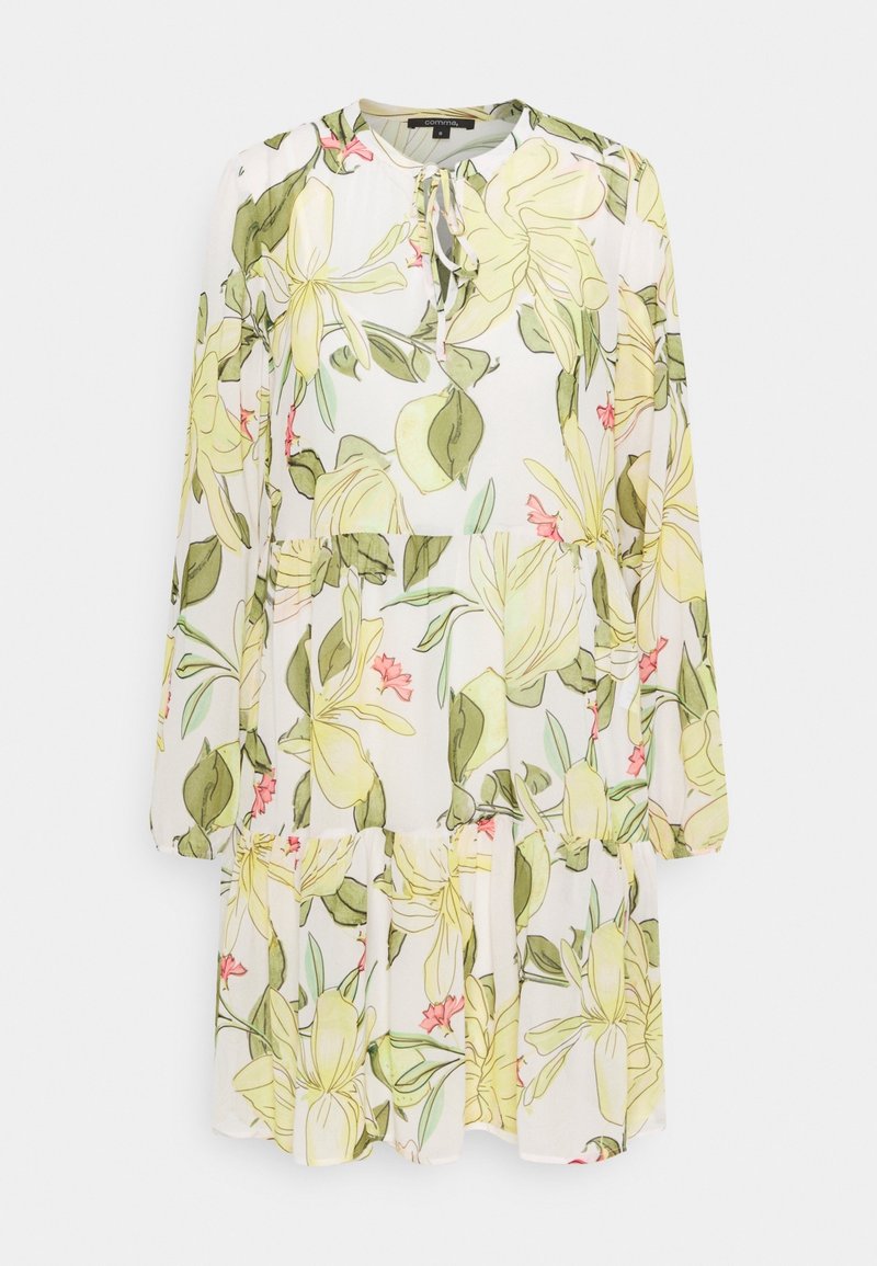 Robe blanche à manches longues avec imprimé floral jaune et vert, col rond, détail noué et jupe à volants.