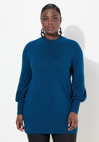 Maglione blu a maniche lunghe con scollatura e polsini ondulati, texture morbida e vestibilità rilassata. Dotato di dettagli delle cuciture sulla parte anteriore.