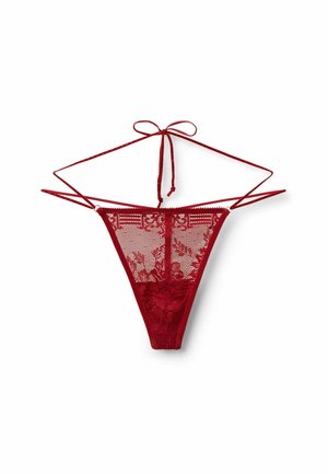 Perizoma rosso in pizzo con motivi floreali e sottili spalline regolabili, annodato a fiocco nella parte superiore, esposto su sfondo bianco.