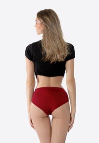 Culotte rouge en coton taille haute avec une texture lisse, présentant une coupe classique, une taille extensible et sans motifs visibles.