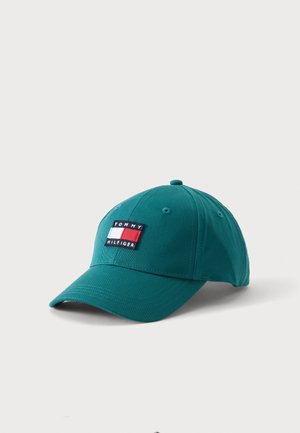Grønblå basebollue med buet skygge og broderet Tommy Hilfiger-logo i rød, hvid og blå foran i midten.