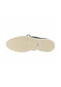 Suola della scarpa con battistrada in gomma beige caratterizzato da motivi esagonali e piccolo dettaglio con bandiera rossa, bianca e verde vicino all'arco.