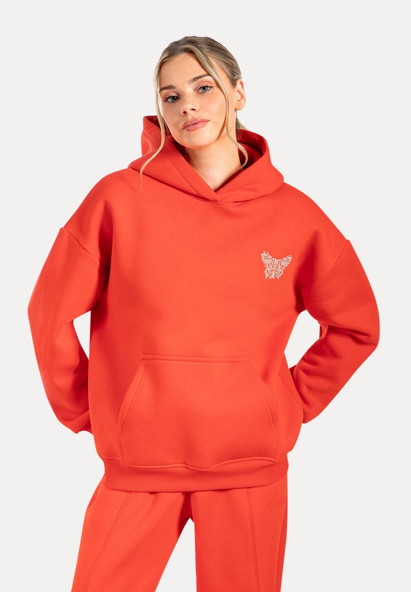 Sudadera naranja brillante de tejido suave con un bolsillo frontal y cortes laterales. Presenta un gráfico decorativo en el pecho. Corte relajado.