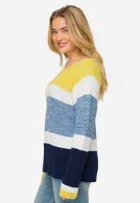 Stickad tröja med horisontella ränder i gult, vitt, blått och marinblått. Löst sittande med långa ärmar och ribbade mudd. Texturerad tyg.