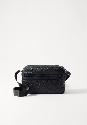 Sort Armani Exchange crossbody taske med præget AX-mønster, frontlomme med lynlås og justerbar stofrem på hvid baggrund.