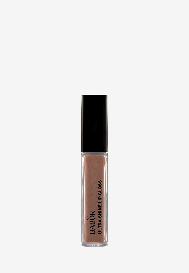 Gloss à lèvres Ultra Shine de Babor dans un tube transparent avec un capuchon noir ; couleur nude crémeuse, texture lisse et étiquette avant bien en évidence.