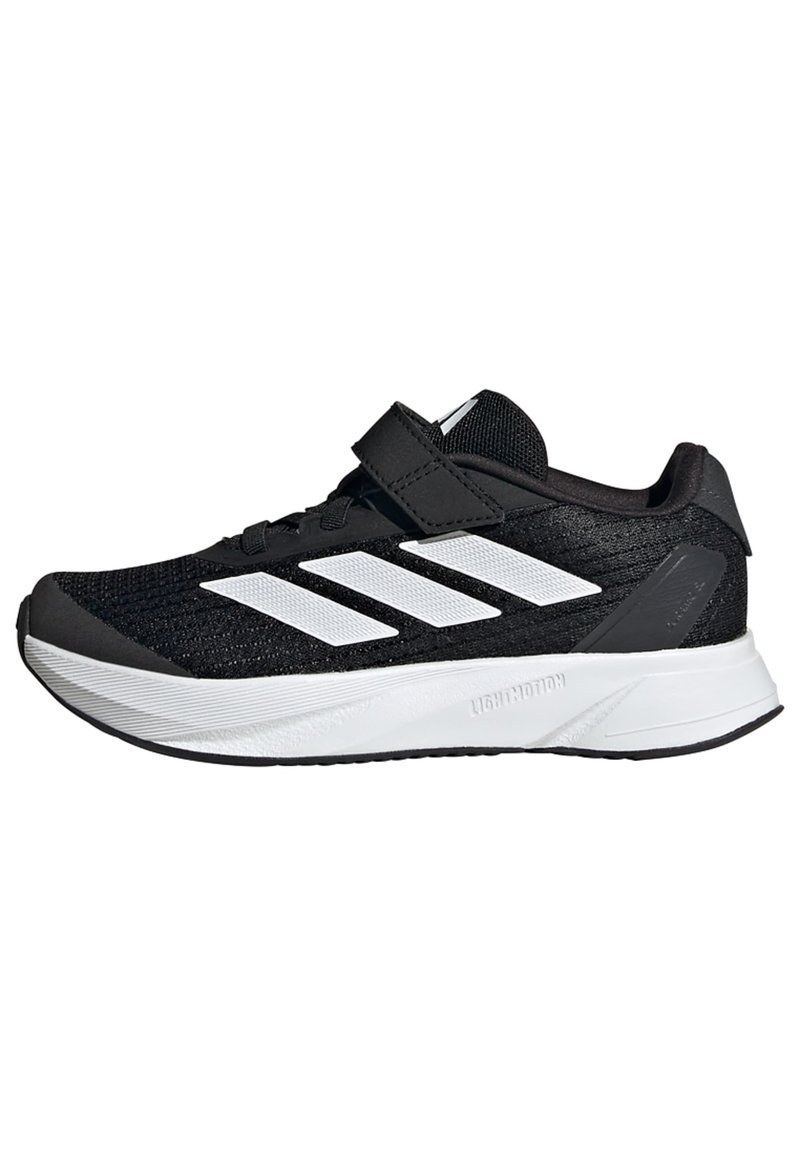 Zapatillas deportivas negras con acentos blancos, que cuentan con una parte superior de malla texturizada, una correa de velcro, una suela ligera y un destacado diseño de tres rayas.