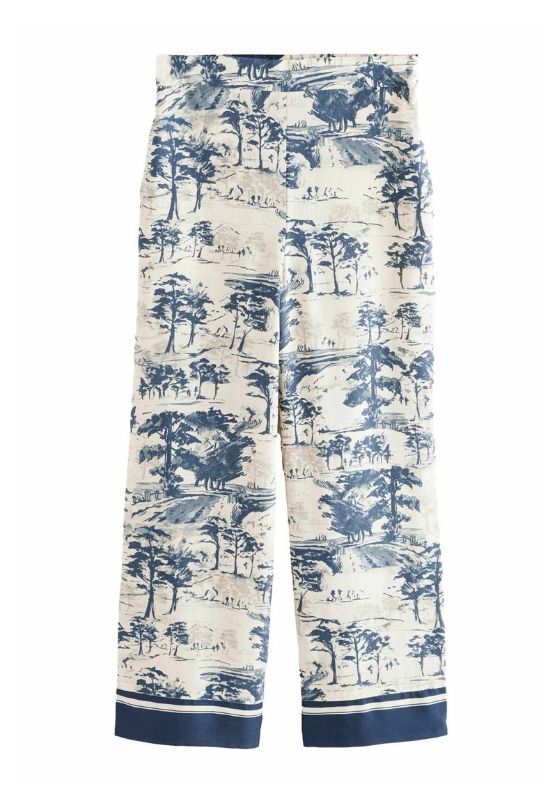Pantalon crème jambes larges avec motifs de paysage bleu et arbres, doté de poignets bleu foncé à rayures blanches aux ourlets.