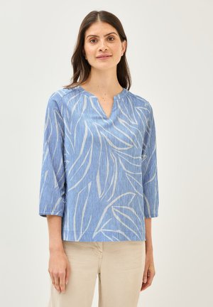 Top a rayas azules con escote en forma de V y mangas de tres cuartos. Presenta un patrón de hojas en blanco. Fabricado en tela ligera.