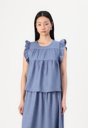 Light blue, linen blend top with ruffled sleeves, round neckline, and layered design. Textured fabric with soft drape, paired with matching skirt.