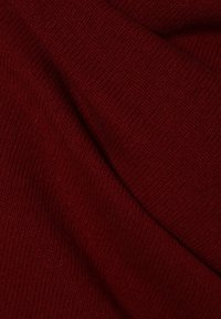 Tissu tricoté bordeaux à texture douce, présentant un motif côtelé dense et un léger éclat, drapé de manière fluide.