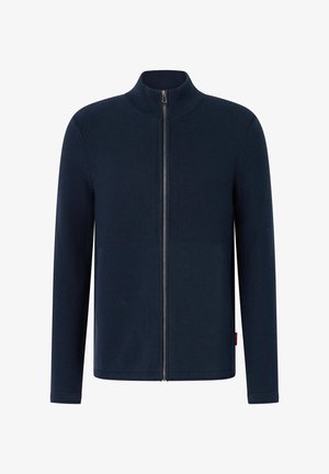 Veste zippée marine, texture côtelée, col montant, manches longues, et fermeture éclair à l'avant, en matière tricotée douce. Design minimaliste.