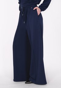 Marineblauwe wijde broek gemaakt van een zachte stof met een koordsluiting in de taille en zijzakken, met een gladde textuur en een ontspannen pasvorm.
