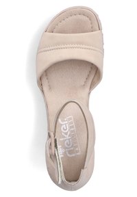 Beige sandal featuring two wide cross straps, a smooth synthetic upper, soft innersole, and a rounded toe design with a buckle detail.