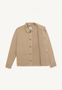 Veste beige à boutons avec col et grande poche avant, étalée à plat avec le devant partiellement ouvert laissant entrevoir la doublure intérieure.