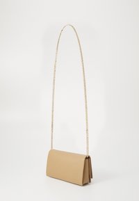 Beige leather handbag with a structured shape, featuring a long gold chain strap and a textured surface. Design includes a flap closure.