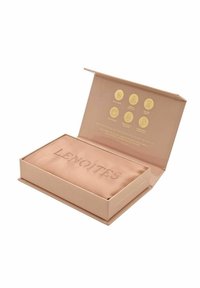 Roséguld rektangulär låda med pr präglad "LENOITES" på en satininteriör. Innehåller sex ikoner i guld som är tryckta på locket och relaterade till produktens fördelar.