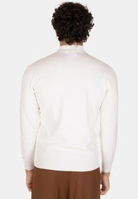 Maglione bianco lavorato a maglia con maniche lunghe, polsini e orlo a coste. Texture liscia, design semplice, senza motivi o dettagli visibili.