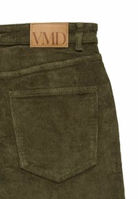 Olijfgroene corduroy broek heeft een leren label met "VMD" gestikt op de tailleband en een achterzak met een verticale naad.