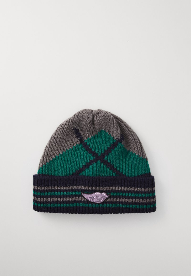 Bonnet tricoté avec un motif géométrique gris, vert et bleu marine et un petit patch de lèvres violettes sur le revers.