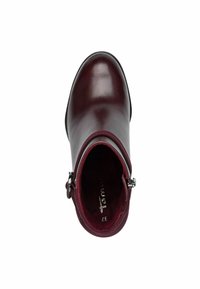 Bottine en cuir bordeaux au design épuré, bout rond, fermeture éclair et texture intérieure contrastante. Accent de quincaillerie minimaliste.