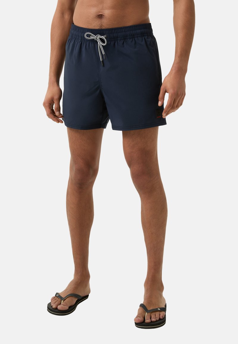 Marineblaue Badeshorts mit elastischem Bund, verstellbarem Kordelzug und einem aufgenähten Logo an der Seite. Der Stoff wirkt leicht und glatt.