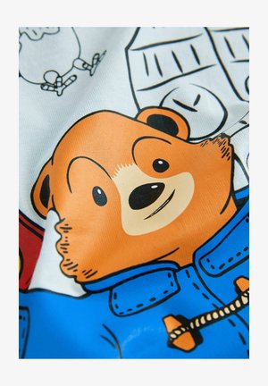 Cartoonbeer met oranje vacht, gekleed in een blauw jasje. De achtergrond bevat eenvoudige, met lijnen getekende elementen in zwart-wit.