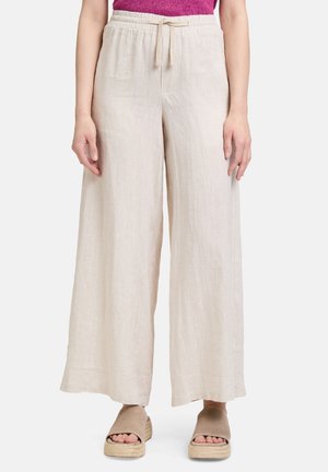 Pantaloni larghi beige in lino con elastico in vita e cordoncino. Tessuto morbido, design a lunghezza completa, abbinati a semplici sandali flat color nocciola.