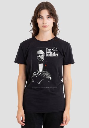 Black cotton t-shirt featuring a grayscale print of a man holding a cat, with "The Godfather" text and a quote below in white.