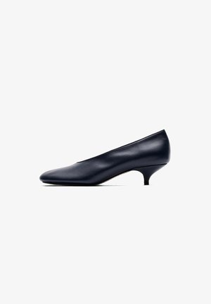 Escarpin en cuir noir à talon bas, bout arrondi et talon fin kitten sur fond blanc.