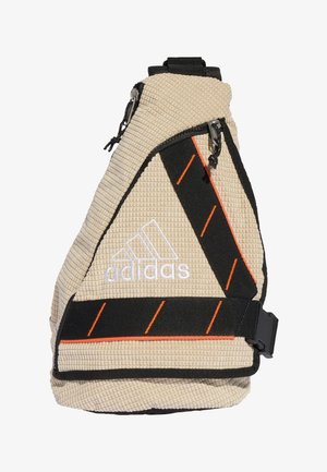 Beige Adidas skuldertaske med tekstureret stof, sort justerbar rem med orange skrå syninger og hvid Adidas-logo.