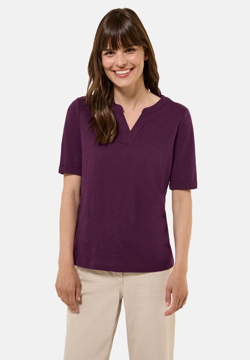 Top a maniche corte color prugna con scollatura a V, realizzato in un tessuto morbido, presenta una vestibilità comoda e con maniche a risvolto.
